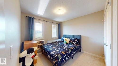 Bedroom featuring neutral wall color, two windows, carpet flooring, and a flush-mount ceiling light fixture - 6824 Evans Wynd Nw, Edmonton, AB - Indoor Photo Showing Bedroom