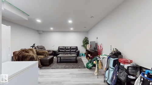 Spacious room featuring light wood-finish flooring, recessed lighting, and white walls - 6824 Evans Wynd Nw, Edmonton, AB - Indoor