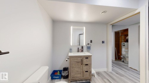 Bathroom featuring a wood-finish vanity with a white countertop and rectangular sink - 6824 Evans Wynd Nw, Edmonton, AB - Indoor