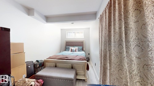 Bedroom featuring light-tone wood-finish flooring, a contemporary window, and recessed lighting - 6824 Evans Wynd Nw, Edmonton, AB - Indoor