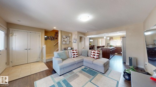 Open-concept living space featuring wood-finish flooring, a neutral color palette, and recessed lighting - 6824 Evans Wynd Nw, Edmonton, AB - Indoor Photo Showing Living Room