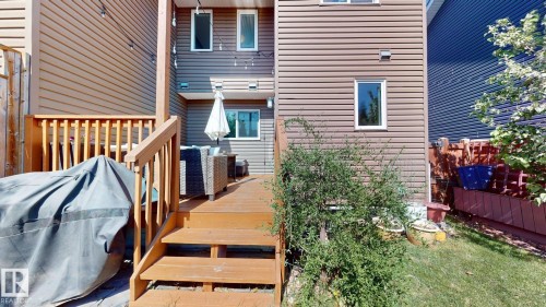 Multi-level wood deck featuring stairs and railing, leading to a lower patio area - 6824 Evans Wynd Nw, Edmonton, AB - Outdoor With Deck Patio Veranda With Exterior