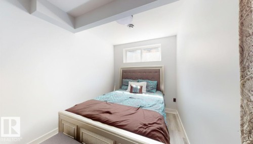 Bedroom featuring light wood-finish flooring and a tray ceiling - 6824 Evans Wynd Nw, Edmonton, AB 