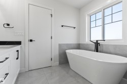 Freestanding soaking tub with a floor-mounted matte black faucet - 