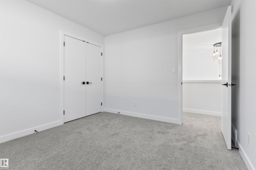 Spacious room featuring light gray carpeting, white walls, and bright white baseboards - 208 Falcon Crescent, Leduc, AB - Indoor Photo Showing Other Room
