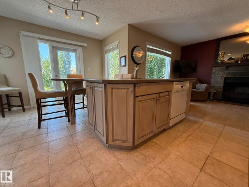 Kitchen island featuring a built-in sink and integrated dishwasher - 5604 57 Avenue, Beaumont, AB 