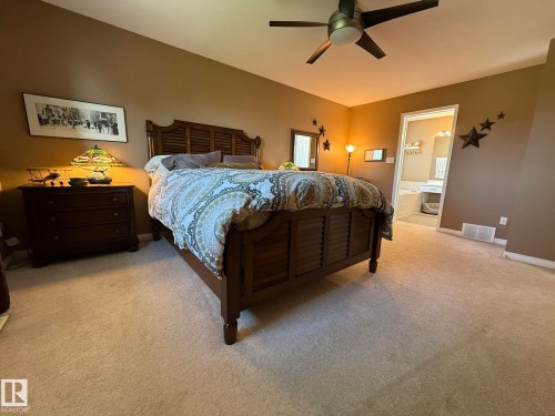 Spacious bedroom with vaulted ceilings and light-colored carpeting - 5604 57 Avenue, Beaumont, AB 