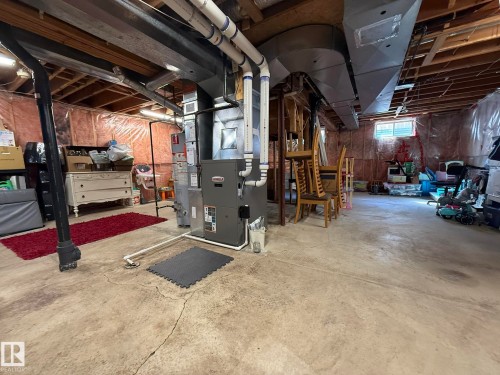 Unfinished basement featuring a concrete floor, exposed ceiling joists, and a utility window - 5604 57 Avenue, Beaumont, AB 