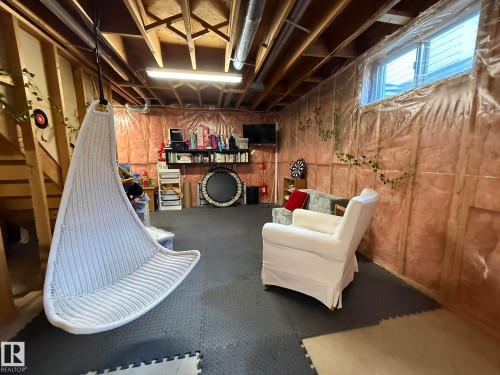 Unfinished basement space featuring exposed wood framing, ceiling joists, and ductwork - 5604 57 Avenue, Beaumont, AB 