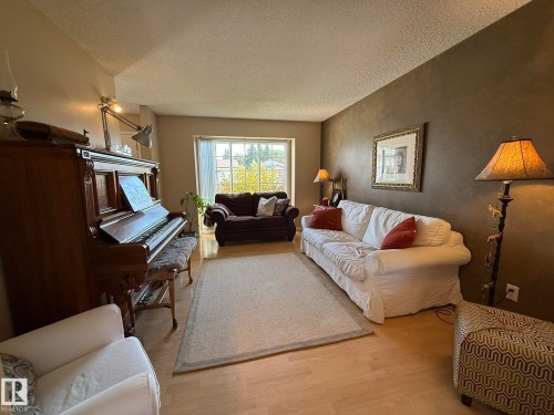 Light wood-finish flooring complements the neutral wall tones - 5604 57 Avenue, Beaumont, AB 