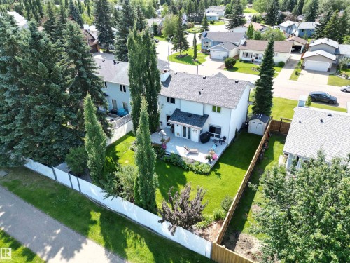 Expansive backyard featuring a manicured lawn, established trees, and a spacious patio area - 5604 57 Avenue, Beaumont, AB 