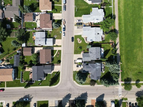 Aerial perspective showcasing a residential neighborhood with a mix of single-story and multi-story homes - 5604 57 Avenue, Beaumont, AB 