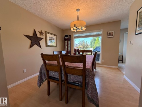 Spacious dining area featuring warm neutral wall tones and light-toned wood-finish flooring - 5604 57 Avenue, Beaumont, AB 
