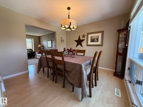Dining area featuring light wood-finish flooring, neutral-toned walls, and an open doorway to another room - 5604 57 Avenue, Beaumont, AB 