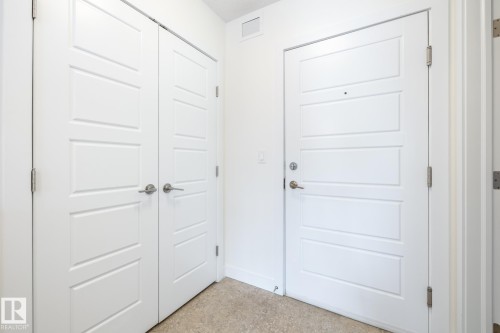 Panel doors featuring brushed nickel hardware - #215 2590 Anderson Wy Sw, Edmonton, AB - Indoor Photo Showing Other Room