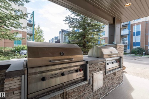Outdoor grilling station featuring two built-in stainless steel grills - #215 2590 Anderson Wy Sw, Edmonton, AB - Outdoor
