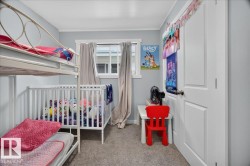 Bedroom featuring light gray walls, white trim, and gray carpet - 