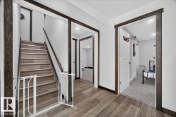 Staircase featuring wood-finish treads and risers, dark wood railings, and white walls - 