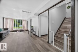 Spacious room featuring wood-finish flooring, recessed ceiling lighting, and a full wall of windows - 