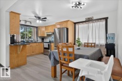 Open-concept kitchen and dining area featuring light wood cabinetry, stainless steel appliances, and wood-finish flooring - 