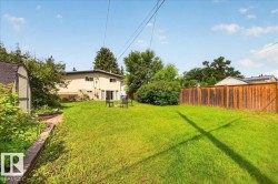 Expansive green lawn with a wood privacy fence - 