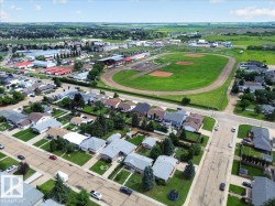 Aerial perspective showcasing a residential neighborhood with single-story homes, established lawns, and mature trees - 