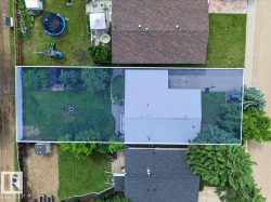 Expansive property featuring a large, landscaped backyard with mature trees, a fire pit, and a shed - 