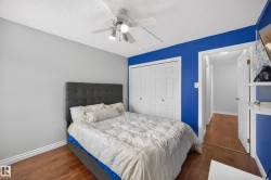 Bedroom featuring wood-finish flooring, a ceiling fan with integrated lighting, and a double bi-fold closet - 