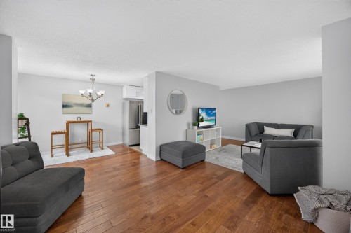 Open-concept living space with wood-finish flooring throughout - #602 9725 106 St Nw, Edmonton, AB 