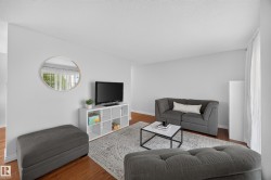 Spacious interior featuring wood-finish flooring, light-toned walls, and white trim - 