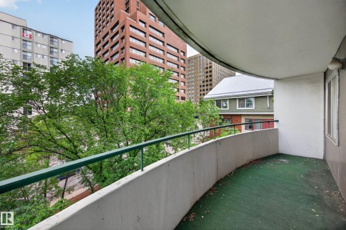 Curved balcony with green railing and concrete wall - #602 9725 106 St Nw, Edmonton, AB 
