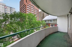 Curved balcony with green railing and concrete wall - 