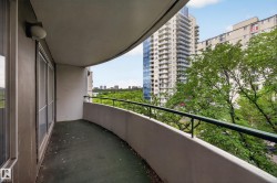 Curved balcony featuring a metal railing and concrete floor - 