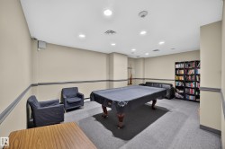 Recreation room featuring a covered billiard table, recessed lighting, wall-mounted speaker, and a built-in bookshelf - 