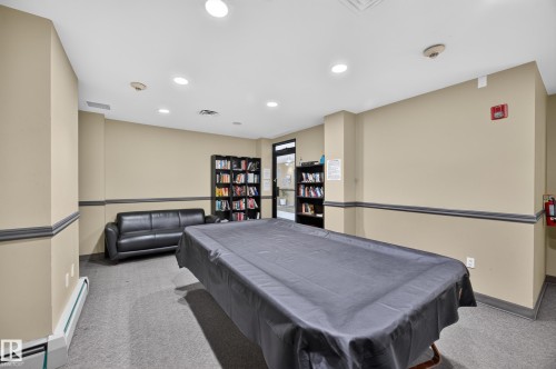 Recreational room featuring a covered pool table, recessed lighting, and carpet flooring - #602 9725 106 St Nw, Edmonton, AB 