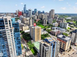 Urban high-rise building with a distinctive beige and white facade, situated amidst a dense city skyline - 