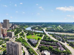 Expansive urban landscape featuring a prominent river, multiple bridges, high-rise buildings, and extensive green spaces - 