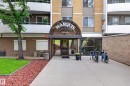 Building entrance featuring a curved glass awning and prominent signage - #602 9725 106 St Nw, Edmonton, AB 