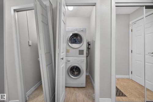 Dedicated laundry area featuring a stacked washer and dryer unit - #602 9725 106 St Nw, Edmonton, AB 