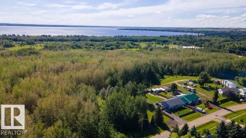 Expansive wooded acreage bordering a large body of water - 4701 34 St., Rural Wetaskiwin County, AB 