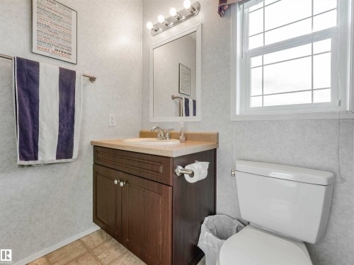 Bathroom vanity with a light-toned countertop, undermount sink, and two-door cabinet storage - 57016 Range Road 13, Rural Barrhead County, AB - Indoor Photo Showing Bathroom