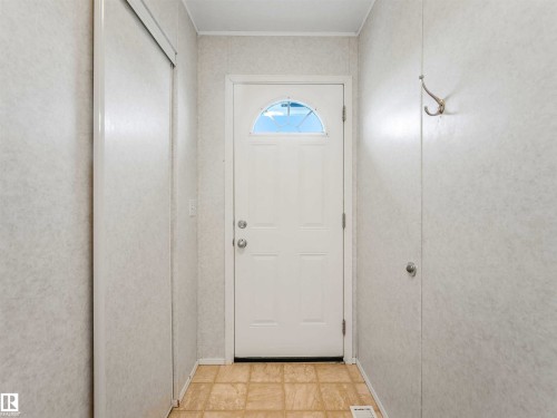 Entryway featuring a white door with an arched window, light-toned tiled flooring, and a built-in coat hook - 57016 Range Road 13, Rural Barrhead County, AB - Indoor Photo Showing Other Room