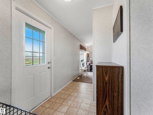 Entryway featuring a white door with divided light window, tiled flooring, and a wood-finish storage cabinet - 57016 Range Road 13, Rural Barrhead County, AB - Indoor Photo Showing Other Room