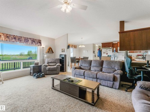 Carpeted living area with a ceiling fan, a large window, and light wall finishes - 57016 Range Road 13, Rural Barrhead County, AB - Indoor Photo Showing Living Room