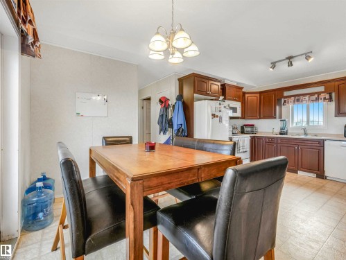 Kitchen featuring wood-finish cabinetry, light-toned countertops, and a white refrigerator - 57016 Range Road 13, Rural Barrhead County, AB - Indoor