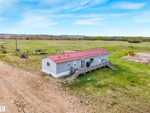 Single-story residence featuring light gray siding and a red metal roof - 57016 Range Road 13, Rural Barrhead County, AB - Outdoor With View