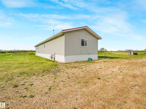 Single-story residence featuring light gray siding, a red roof, and white trim - 57016 Range Road 13, Rural Barrhead County, AB - Outdoor With Exterior
