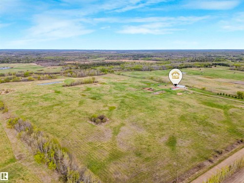 Expansive aerial view of a property featuring extensive green acreage and distant treelines - 57016 Range Road 13, Rural Barrhead County, AB - Outdoor With View