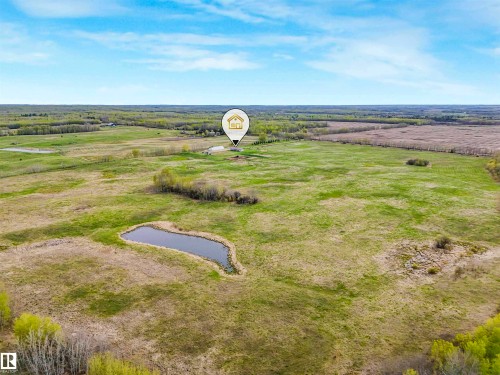 Expansive rural acreage featuring a natural pond and scattered trees - 57016 Range Road 13, Rural Barrhead County, AB - Outdoor With View