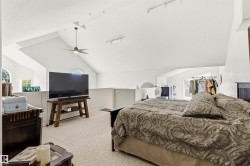 Open loft area featuring vaulted ceilings, a ceiling fan, and carpeted flooring - 